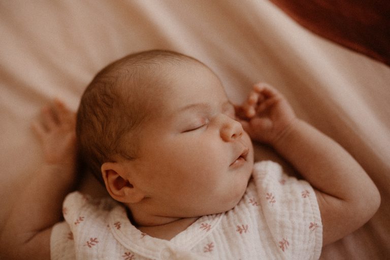 photographie d'un nouveau né en train de dormir paisiblement