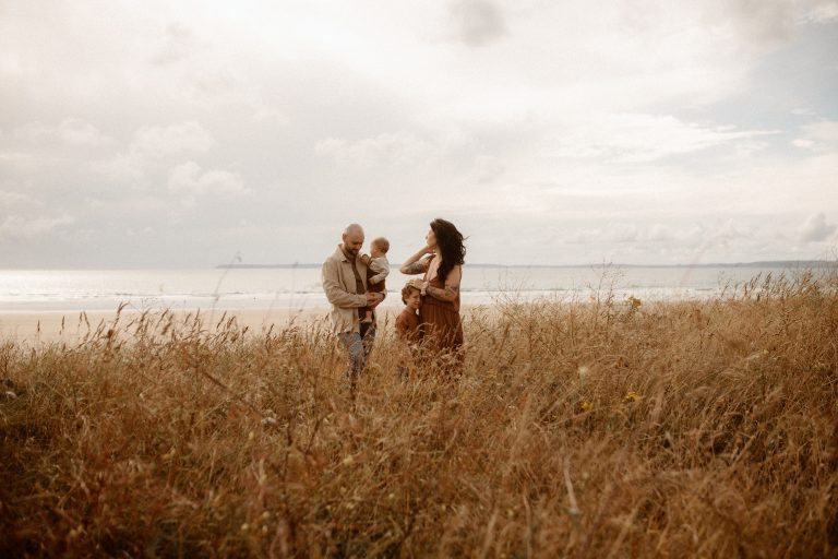 photographie d'une famille au milieu des herbes sauvages au bord de mer