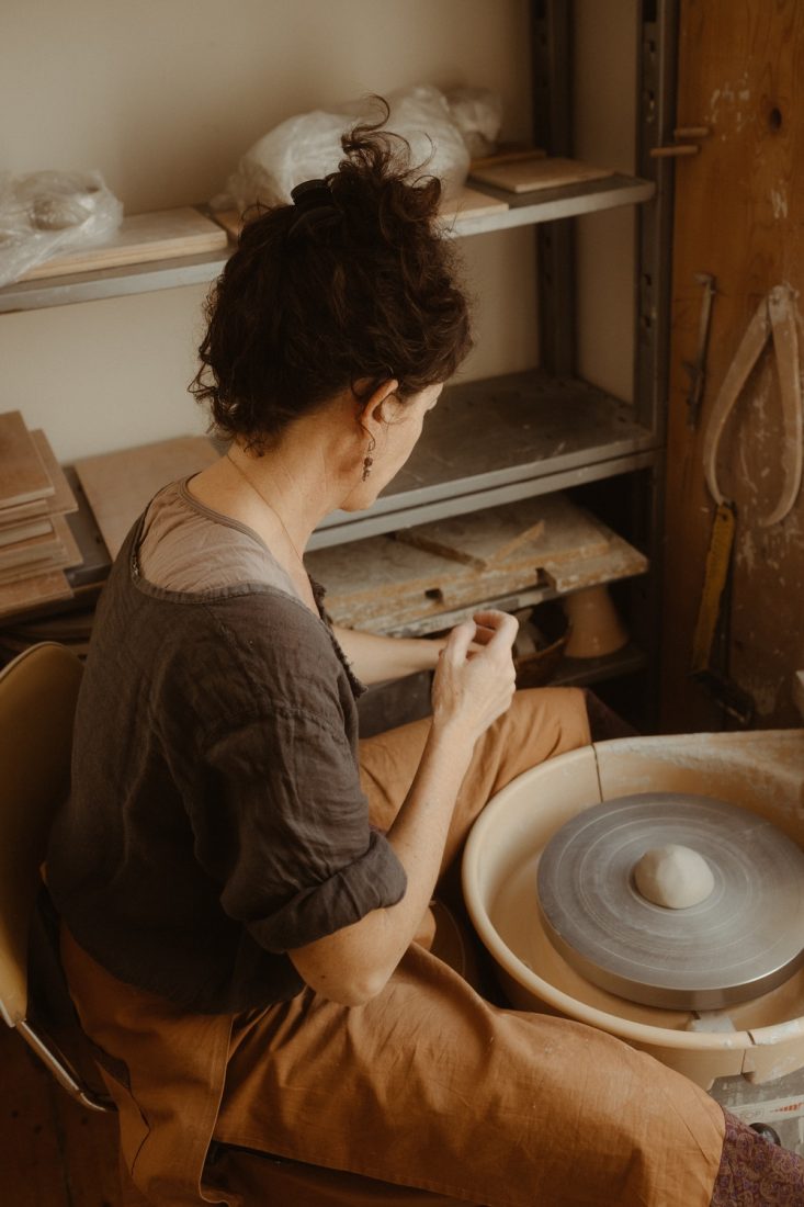 Portrait d'une artisan-céramiste devant son tour de poterie